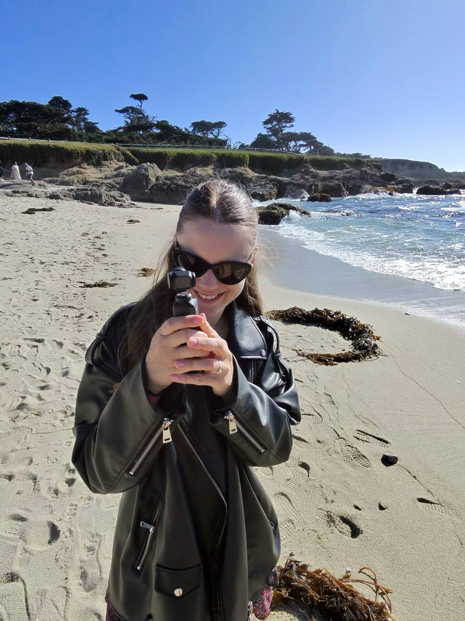 Anastasiia filming with DJI Pocket 3 on a California beach
